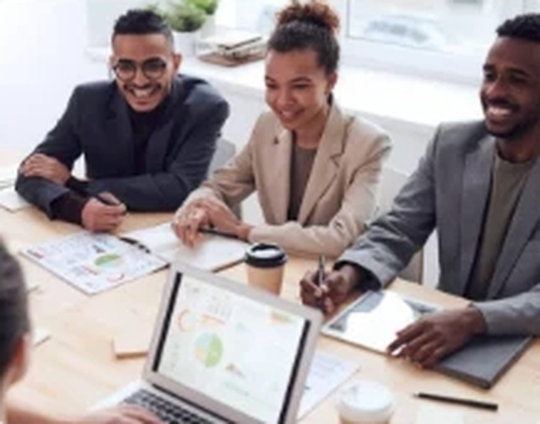 Three colleagues smiling during a meeting